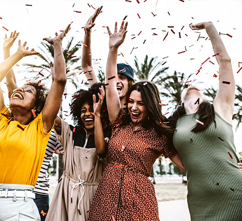NLP Seminar: Glückliche Gruppe feiert Erfolg mit Konfetti im Freien.