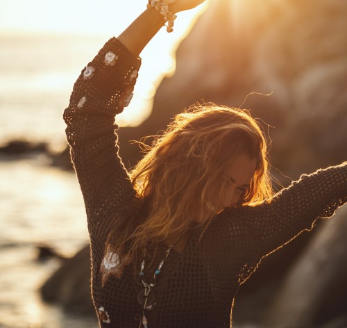 Frau genießt Freiheit am Strand. NLP Basic Seminar für mehr Erfolg.